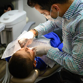 dentist working on young boy's smile