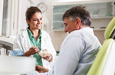 Smiling dentist talking to patient during consultation