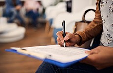 Woman filling out dental insurance form in lobby