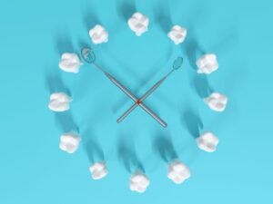 12 toy teeth and 2 dental mirrors arranged like a clock on a light blue background